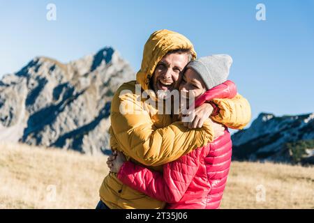 L'Autriche, le Tyrol, l'heureux couple hugging en randonnée dans les montagnes Banque D'Images