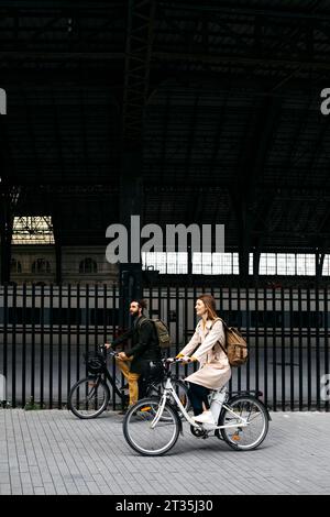 Couple riding e-bikes dans la ville Banque D'Images