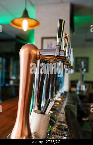 Robinets de brasserie brillants en rangée au pub Banque D'Images