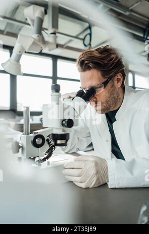 Scientifique mature travaillant sur microscope en laboratoire Banque D'Images