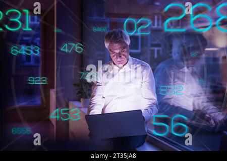 Chiffres futuristes se déplaçant vers l'homme d'affaires senior travaillant sur ordinateur portable dans le bureau Banque D'Images