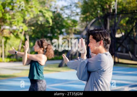 Amis faisant des exercices d'étirement sur le terrain de sport Banque D'Images