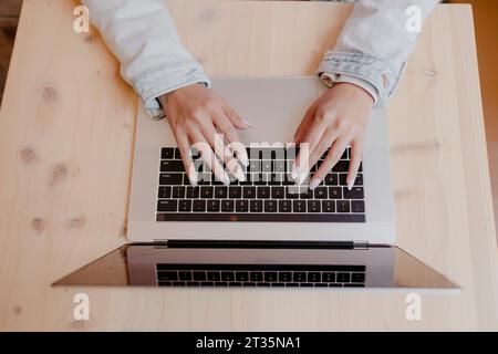 Mains de femme tapant sur ordinateur portable au bureau Banque D'Images