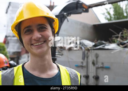 Ouvrier souriant en col bleu par camion dumper Banque D'Images