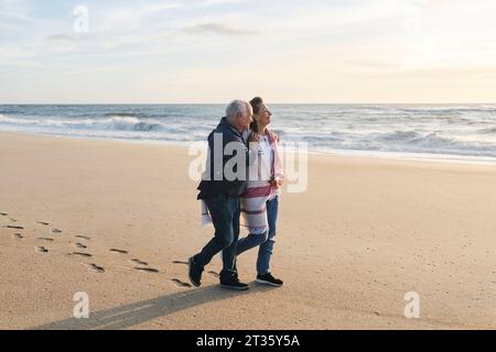 Amoureux couple senior marchant sur le sable à la plage Banque D'Images