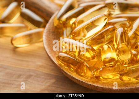 Fermer des capsules avec de la vitamine D, E ou des acides gras oméga 3,6,9 en bouteille sur de vieux fonds en bois. Huile de poisson remplie d'huile de complément alimentaire. Suppl. Naturelle Banque D'Images