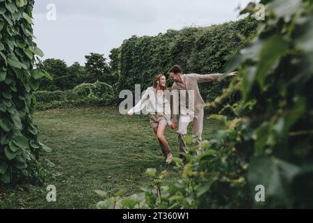 Heureux couple courant dans le jardin Banque D'Images