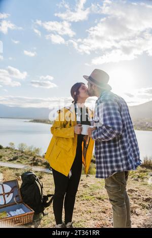 Couple romantique s'embrassant en face du lac Banque D'Images