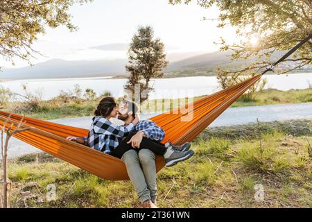 Couple affectueux se détendant dans un hamac Banque D'Images
