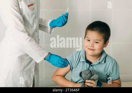 Femme médecin donnant la vaccination au garçon à la clinique médicale Banque D'Images