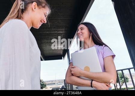 Deux jeunes femmes parlant sur le balcon Banque D'Images