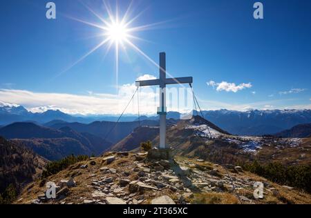 Autriche, Salzburger Land, soleil brillant au-dessus de la croix de sommet sur la montagne Osterhorn Banque D'Images