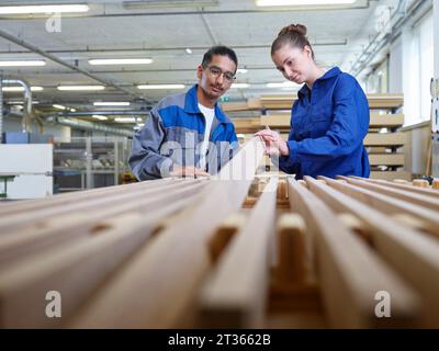 Stagiaires examinant la planche de bois en atelier Banque D'Images