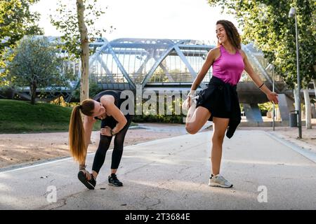 Les femmes font de l'exercice d'échauffement sur le sentier au parc Banque D'Images