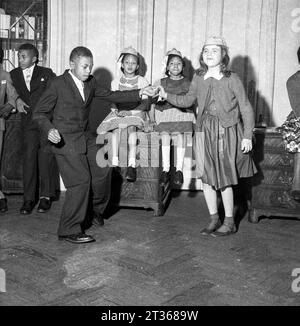 Les enfants Windrush profitent d'une fête avec les habitants de Londres dans les années 1950 Banque D'Images