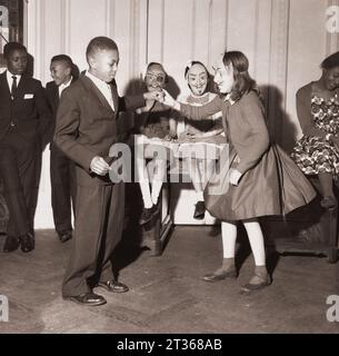 Les enfants Windrush profitent d'une fête avec les habitants de Londres dans les années 1950 Banque D'Images