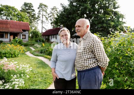 Heureux couple senior debout dans le jardin Banque D'Images