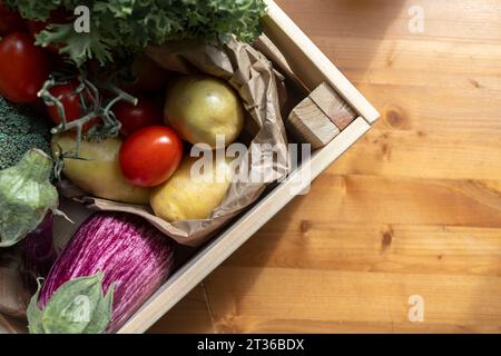 Légumes biologiques frais dans la caisse sur la table en bois Banque D'Images