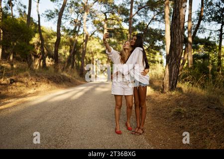 Femme prenant selfie avec une fille adolescente dans la forêt Banque D'Images