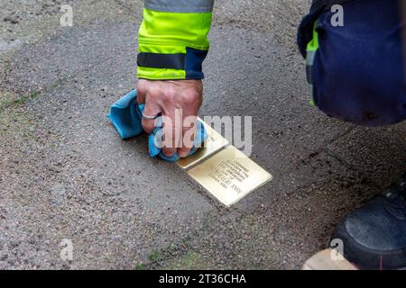 Wiesbaden, Allemagne - 17 octobre 2023 : un maçon pose Stolpersteine sur un trottoir dans le centre-ville de Wiesbaden, Allemagne. Un Stolperstein (littéralement « pierre d'achoppement ») est un cube de béton muni d'une plaque de laiton portant le nom et les dates de vie des victimes de l'extermination nazie. Banque D'Images