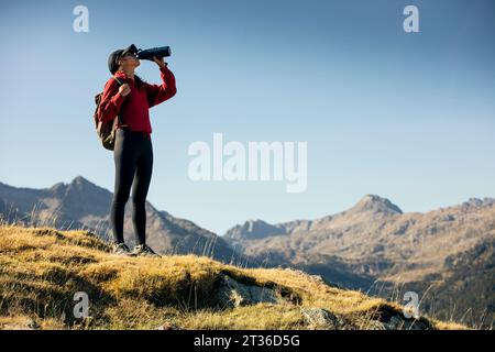 Jeune femme avec sac à dos boire de l'eau de bouteille sur la journée ensoleillée Banque D'Images