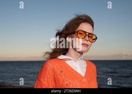 Jeune femme portant des lunettes de soleil devant la mer Banque D'Images