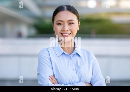 Portrait de la jeune femme d'affaires asiatique confiante debout dans la zone urbaine Banque D'Images