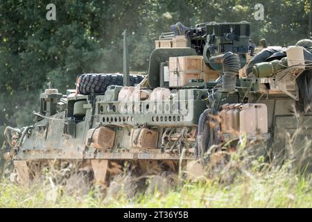 Véhicule de combat à 8 roues lourdement chargé USA Stryker en mouvement Banque D'Images