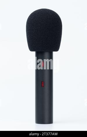Microphone cardioïde noir avec coupe-vent isolé sur fond de studio blanc Banque D'Images