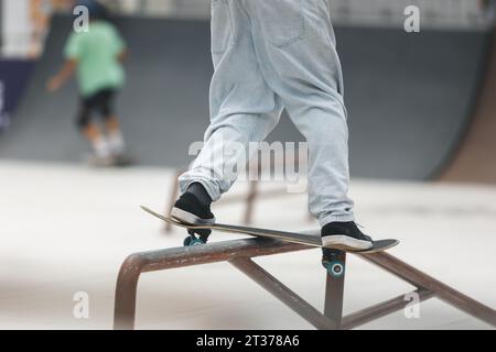 Patineur effectuant un tour avec un pied hors de la planche. Banque D'Images