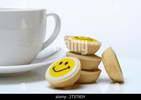 Pâtisserie avec visage souriant et tasse à café, symbole Banque D'Images