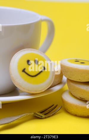 Pâtisserie avec visage souriant et tasse à café, symbole Banque D'Images