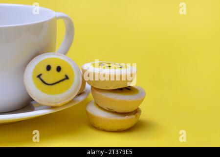 Pâtisserie avec visage souriant et tasse à café, symbole Banque D'Images