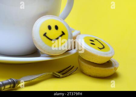 Pâtisserie avec visage souriant et tasse à café, symbole Banque D'Images