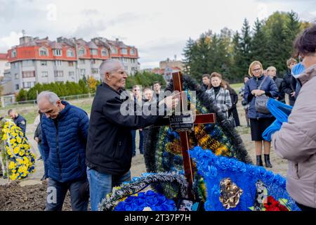 Lviv, Ukraine. 23 octobre 2023. Un parent du soldat ukrainien tombé au combat, Oleksandr Leschenko, a vu ranger le tribut floral sur sa tombe au cimetière militaire de Lychakiv à Lviv. Au fur et à mesure que la guerre russo-ukrainienne progressait, assister aux funérailles des soldats ukrainiens tombés au combat est devenu une activité quotidienne pour les Ukrainiens. Trois funérailles ont lieu aujourd'hui en mémoire des trois jeunes soldats ukrainiens morts la semaine dernière sur la ligne de front, Nazarii Andrushkiv, Oleksandr Leshchenko et Pavlo Plyusnine, au cimetière militaire de Lychakiv à Lviv. Crédit : SOPA Images Limited/Alamy Live News Banque D'Images