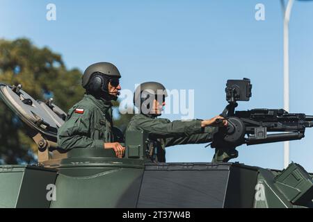 16.08.2023 Varsovie, Pologne. Portrait en plein air de deux soldats militaires polonais concentrés dans des casques et de l'équipement parlant jetant un coup d'œil hors d'un véhicule militaire. Photo de haute qualité Banque D'Images