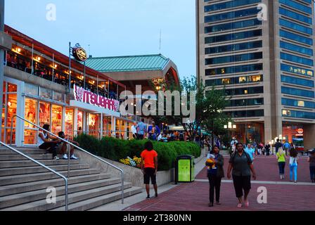 Les gens profitent d'une chaude nuit d'été en marchant autour des magasins de détail et des magasins de la zone Inner Harbor de Baltimore Banque D'Images