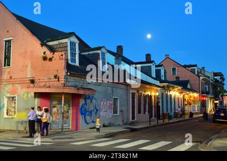Graffiti mars les murs des maisons historiques dans le quartier français de la Nouvelle-Orléans avec la pleine lune se levant sur la ville Banque D'Images
