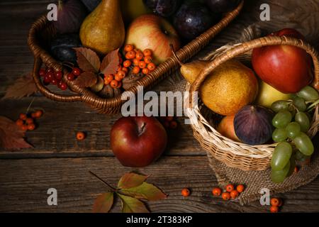 Paniers en osier avec différents fruits frais sur fond en bois Banque D'Images