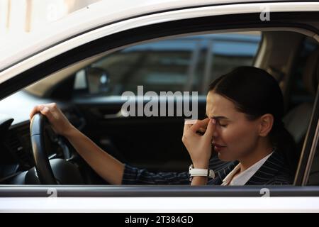 Chauffeur fatigué dans sa voiture, vue de l'extérieur. Coincé dans un embouteillage Banque D'Images