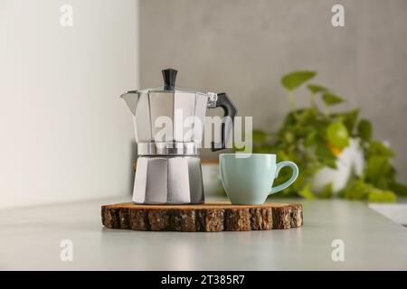 Tasse en céramique et pot moka sur comptoir léger dans la cuisine Banque D'Images