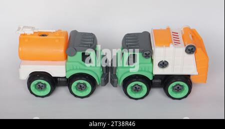 Deux jouets de camion en plastique DIY isolé sur fond blanc. camion d'eau et camion d'ordures. DIY assembler jouet pour augmenter la créativité de l'enfant. Banque D'Images