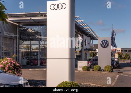 Neuwied, Allemagne -21 octobre 2023 : un pylône avec le logo AUDI devant un autre avec le logo VW (Volkswagen) et le showroom du local A. Banque D'Images