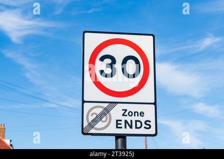 Un panneau de signalisation indiquant une limite de vitesse maximale de 30 mph après la zone de 20 mph se termine par un cercle d'avertissement rouge et blanc Banque D'Images