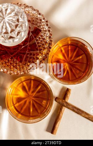 Vue de dessus de verres de whisky placés sur la table près de carafe et bâtons de cannelle Banque D'Images