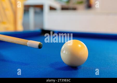 Gros plan de boule de billard blanc sur la table de billard bleu près de repère sur fond flou dans la barre Banque D'Images