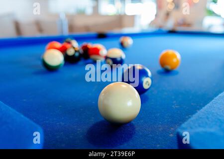Gros plan de boules de billard colorées sur la table de billard bleue à la lumière du jour Banque D'Images