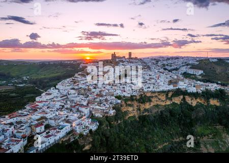 D'en haut des maisons de village Juzcar situées dans la région de Pueblos Blancos en Andalousie avec des arbres verts et des collines sous le ciel de coucher du soleil dans la ville d'Espagne Banque D'Images