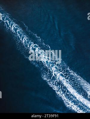 Vue aérienne de dessus de trace mousseuse dans l'eau de mer bleu foncé de bateau à moteur rapide à El Rompido Banque D'Images