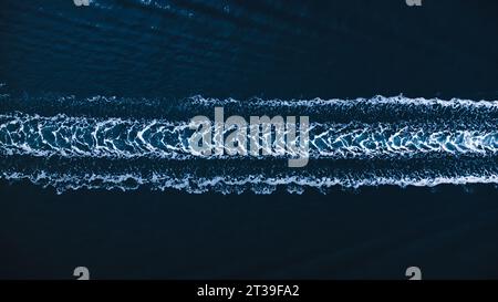 Vue aérienne de dessus de trace mousseuse dans l'eau de mer bleu foncé de bateau à moteur rapide à El Rompido Banque D'Images